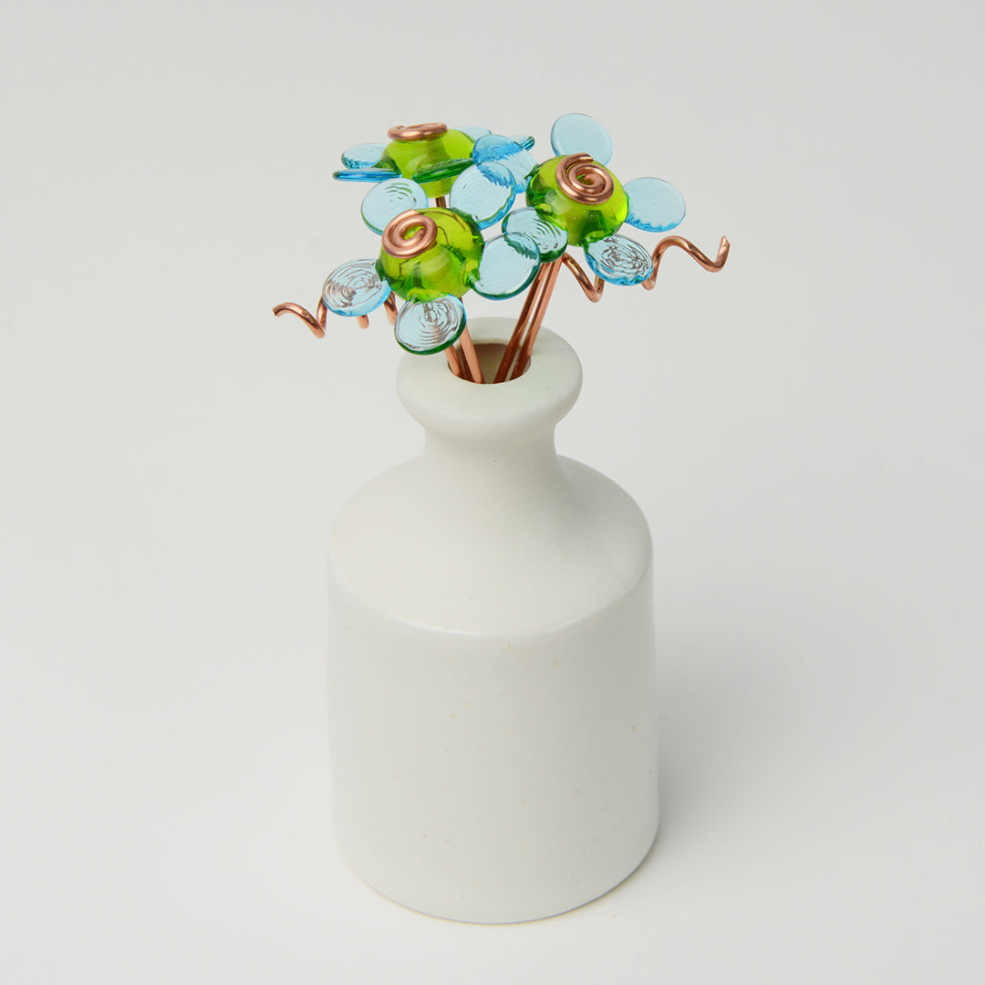 'Cool Skies' bouquet of three turquoise glass daisy flowers in a miniature bottle vase