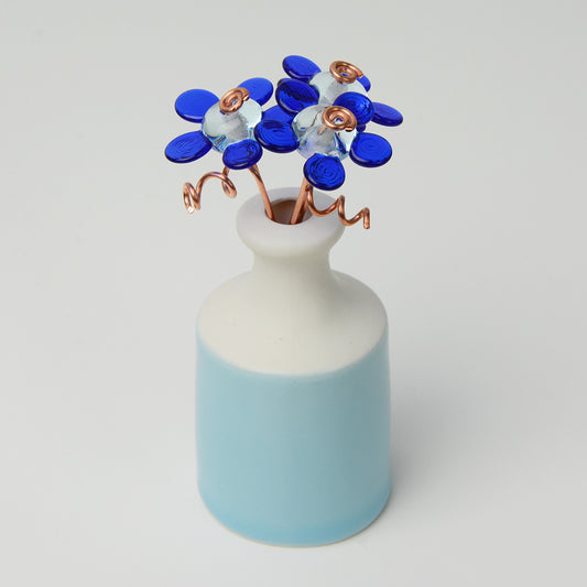 'True Blue' bouquet of three blue glass daisy flowers in a miniature bottle vase