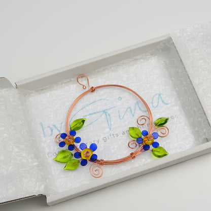 Miniature copper wreath with blue glass flowers and green glass leaves in white gift box