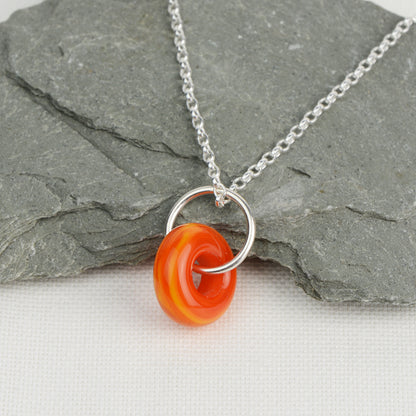Orange glass doughnut shaped bead pendant on silver chain