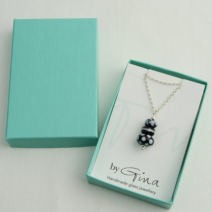 Three black and white glass beads making a pendant on silver chain in turquoise gift box